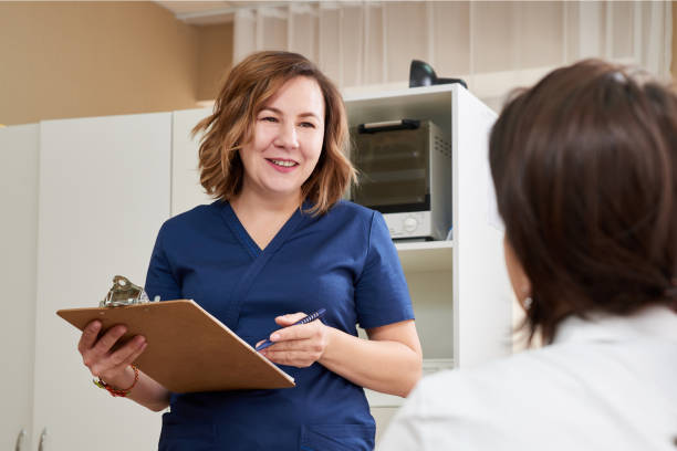 istock doctor is talking with young female patient and making notes while standing near 1283826235