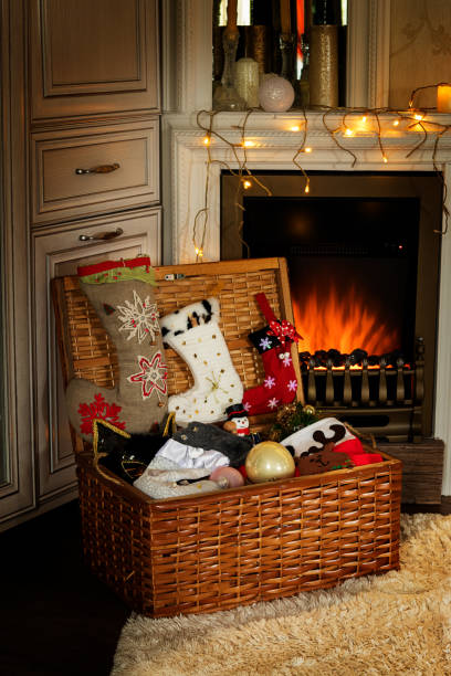 istock Opened wicker box with Christmas decoration is next to fake fireplace. 1283826382