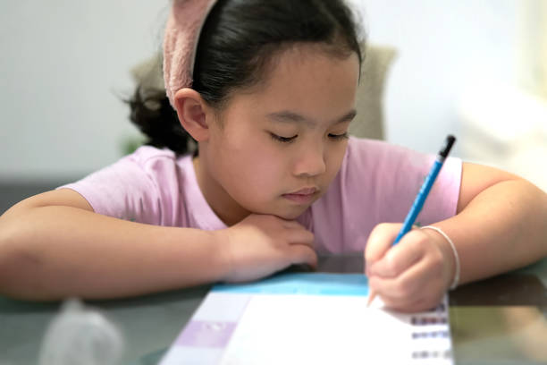 istock female girl is writing on table while learning at home 1283826411