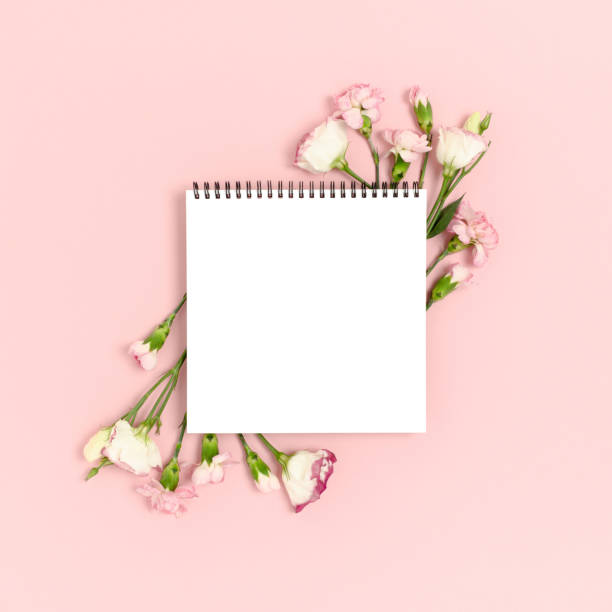 istock Blank notepad mockup with frame made of flowers. Greeting card concept on a pink pastel background. 1283826842