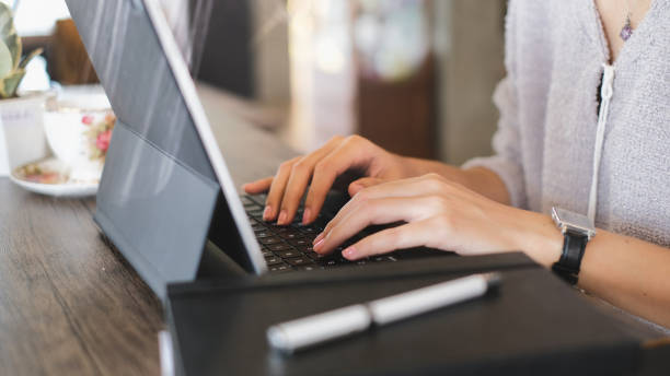 Cropped shot of young female freelancer hands typing on keyborad of computer laptop on wooden table. Cropped shot of young female freelancer hands typing on keyborad of computer laptop on wooden table. keyborad stock pictures, royalty-free photos & images