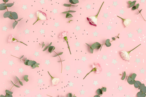 istock Pattern made of eucalyptus, eustoma, carnation flowers and stars confetti. Holiday concept on a pink pastel background. 1283828655