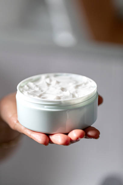 istock Holding a jar of white face cream 1283828950