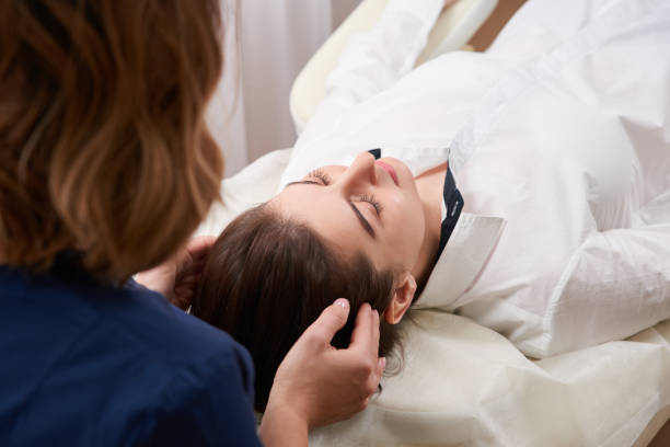 красивая молодая женщина получение лица и головы лечение в салоне красоты - head massage стоковые фото и изображения