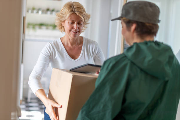 istock Middle aged woman holding the package received from courier at home 1283832952