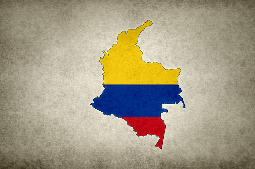 Grunge map of Colombia with its flag printed within its border on an old paper.