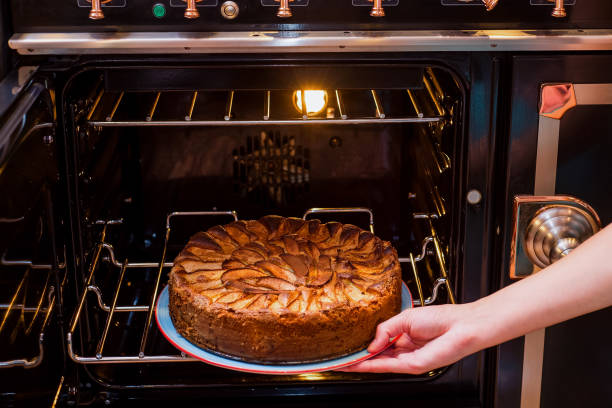 Hands take homemade apple pie out of the oven. Apple pie baking in oven. Traditional French apple pie in the oven. Hands take homemade apple pie out of the oven. Apple pie baking in oven. Traditional French apple pie in the oven. apple pie a la mode stock pictures, royalty-free photos & images