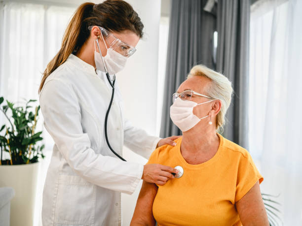 doctor using stethoscope listening to senior patients breathing - visit hospital patient senior adult imagens e fotografias de stock