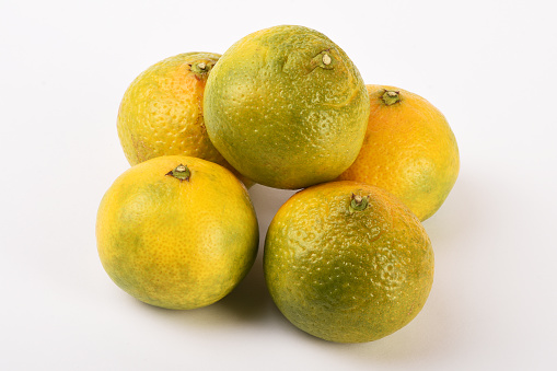 Pile of fresh organic tangerine fruits, mandarins on the white background