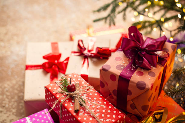 istock Christmas presents piled up on a beige floor under the fir-tree. 1283839943