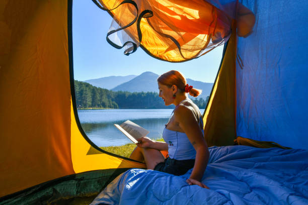 istock Woman reading a book in tent 1283840404
