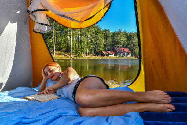istock Woman reading a book in tent 1283840655