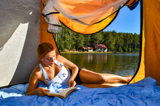 istock Woman reading a book in tent 1283841553