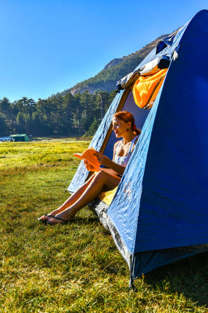 istock Woman reading a book in tent 1283841646
