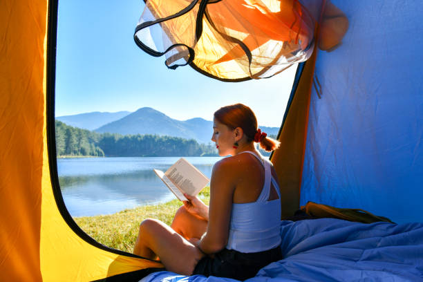 istock Woman reading a book in tent 1283841694