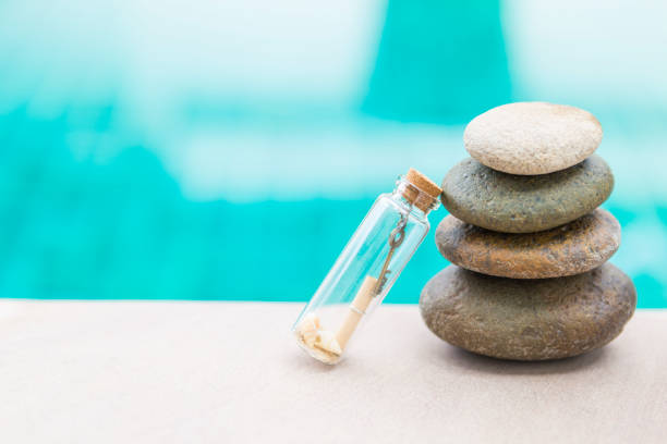 istock Clear glass bottle with key in heart shape and letter with seashell 1283842597