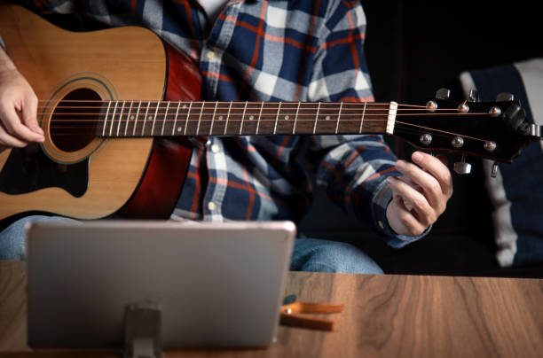 istock Man tuning acoustic guitar at home 1283842669