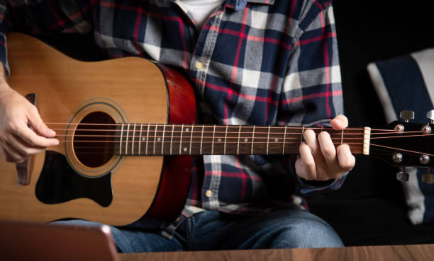 istock Man playing acoustic guitar at home 1283842846