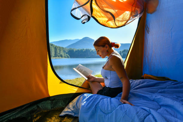 istock Woman reading a book in tent 1283843210