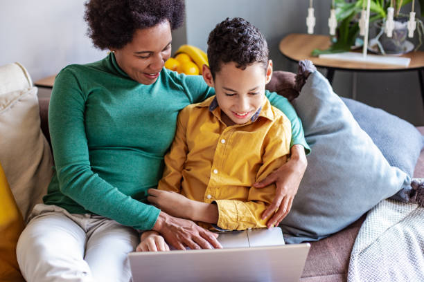 istock Mature woman with her son at home using laptop 1283843513