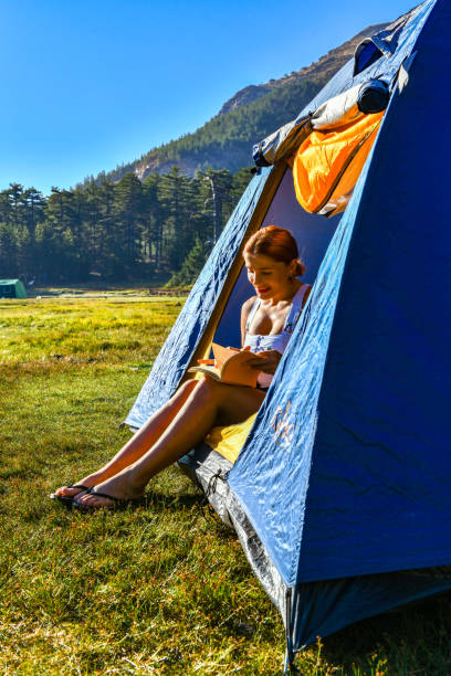 istock Woman reading a book in tent 1283844029