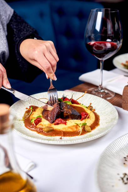 istock Female hands cut meat in a plate. 1283844330