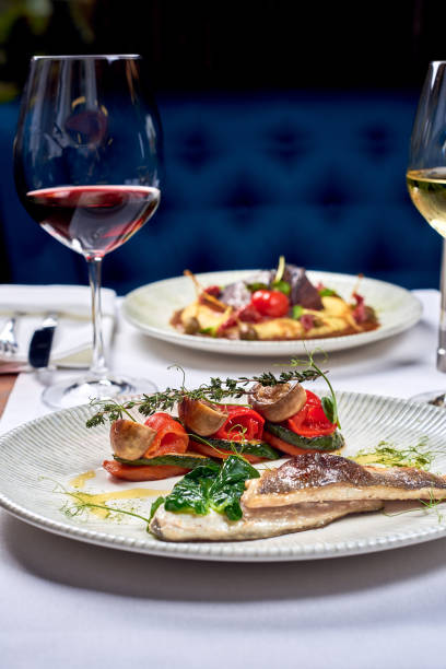 istock A fish dish and a meat dish and wine. 1283844336
