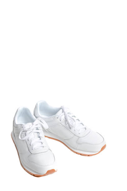 istock Pair of New White Modern Sneakers Over White Background. Vertical Shot 1283845655