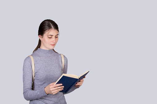 Young beautiful woman handing a book over to the camera