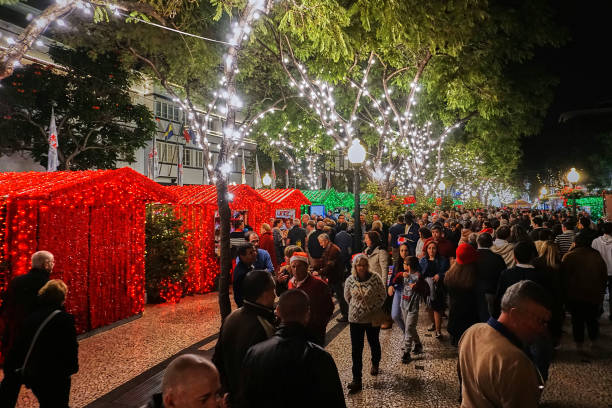 Christmas Funchal, Portugal - December 23, 2018: Crowd of people at the Christmas market in Funchal at night. funchal christmas stock pictures, royalty-free photos & images