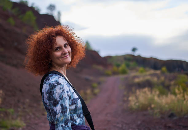 Redhead curly lady at sunset inside an extinct volcano