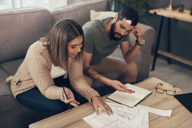 It might be time for some debt relief Shot of a young couple looking stressed while going over paperwork at home pictures of divorce papers stock pictures, royalty-free photos & images