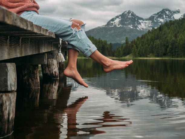 ноги свисающие с причала озера - switzerland engadine european alps lake стоковые фото и изображения