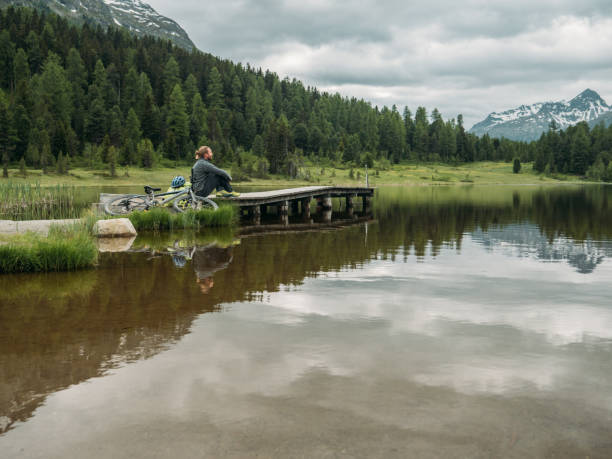 istock Mountain biker relaxes by the lake 1283851148