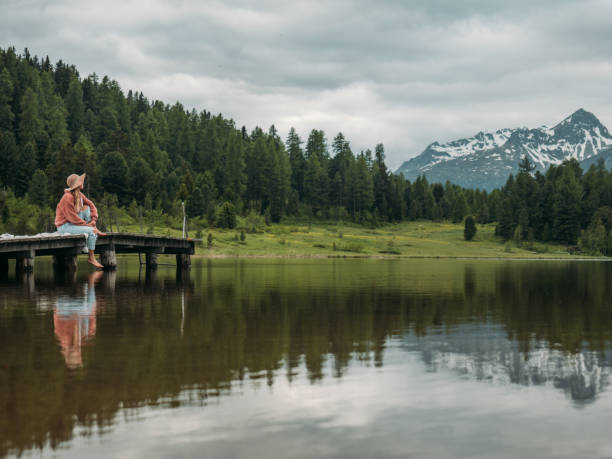 istock Young woman relaxing on lake pier 1283851288