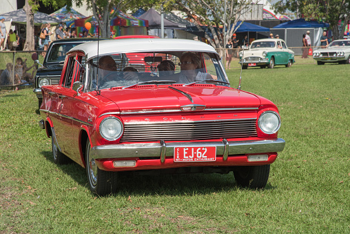 Darwin, NT, Australia-July 27,2018: Vintage car parade with vivid red Holden at the Darwin Show Day in the NT