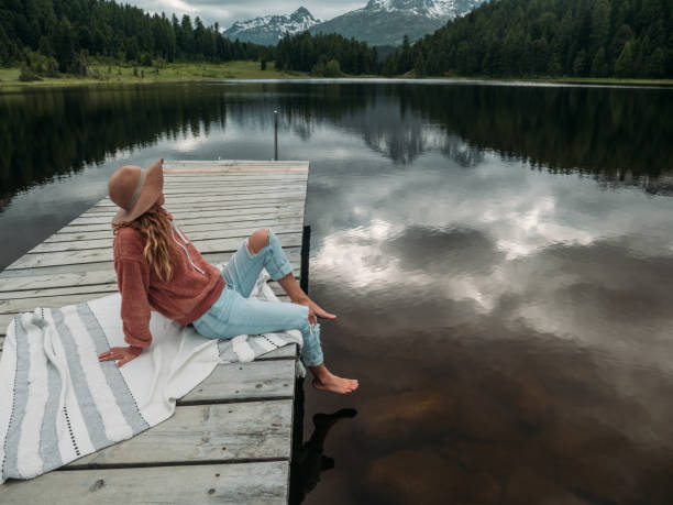 istock Young woman relaxing on lake pier 1283851315