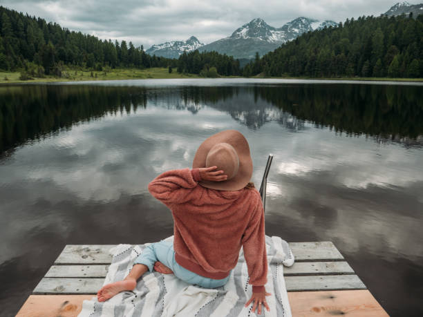 istock Young woman relaxing on lake pier 1283851322