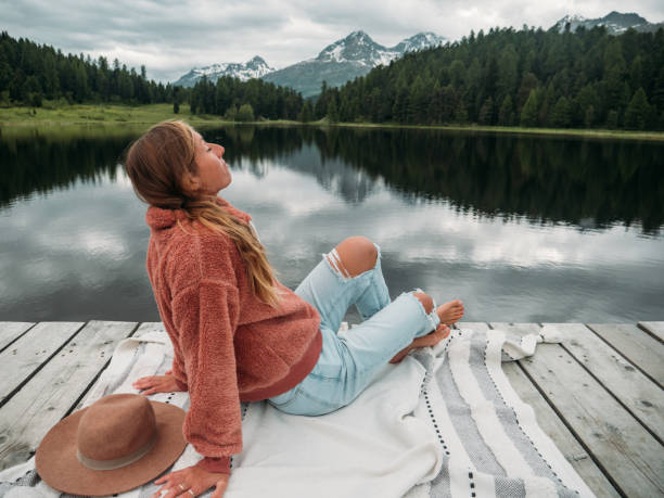 istock Young woman relaxing on lake pier 1283851388