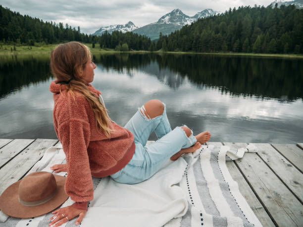 istock Young woman relaxing on lake pier 1283851466