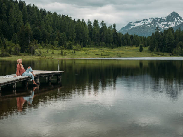 istock Young woman relaxing on lake pier 1283851599