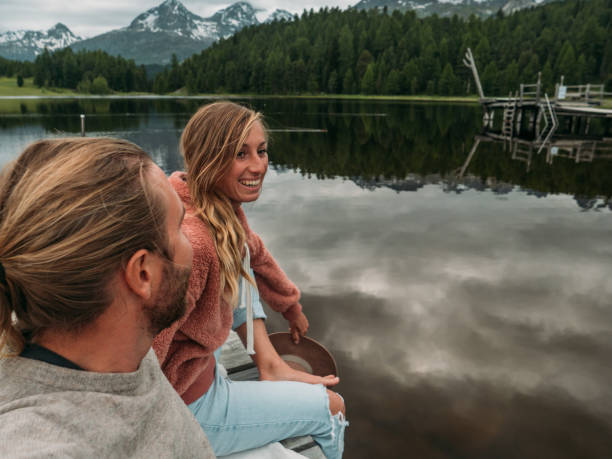 istock Couple relaxing on lake pier 1283852145