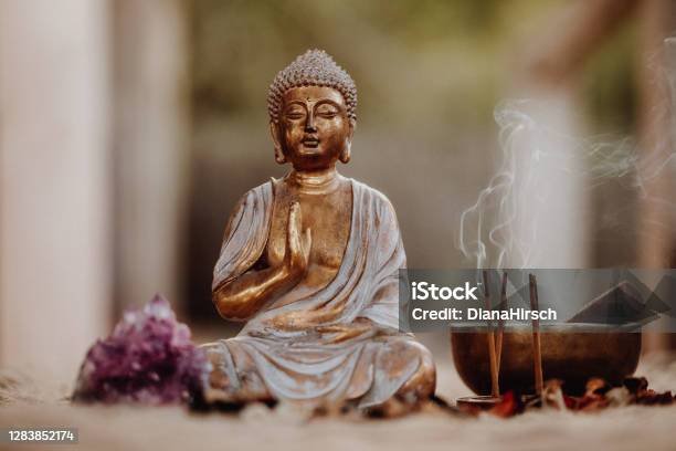 Close Up Of A Buddha Figurine And Smoky Incense With Gong And Amethyst Stock Photo - Download Image Now