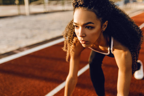 istock Young athletic african american runner at stadium starting line getting ready for race, sport concept 1283852313