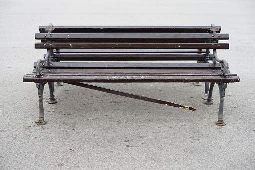 A broken part of a wooden bench on the street