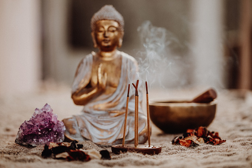 Close up of an Incense with Buddha figurine, gong and amethyst. Focus on the Incense.