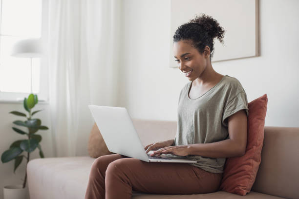 istock Woman working from home. Student girl using laptop on sofa 1283852995