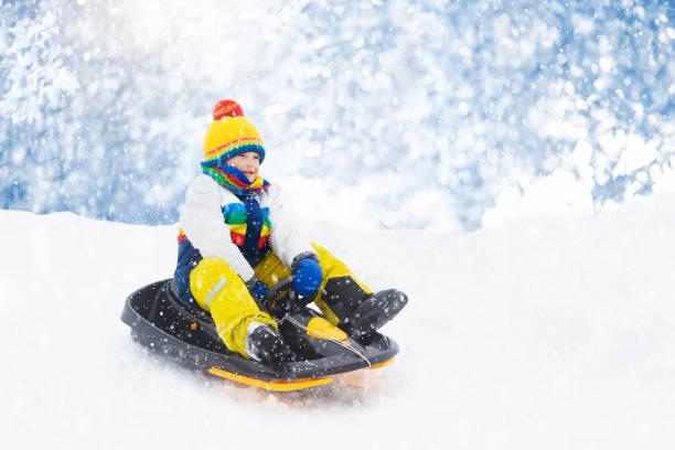 istock Boy on sled ride. Child sledding. Kid on sledge 1283854241