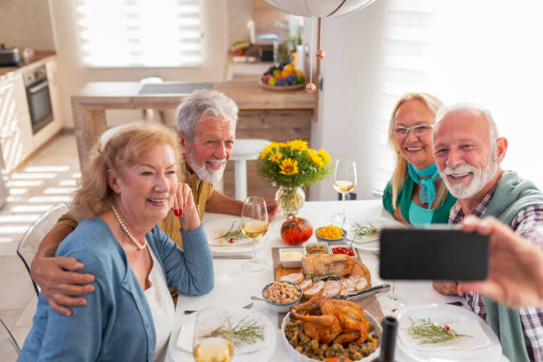 Senior friends taking a selfie while having Thanksgiving dinner