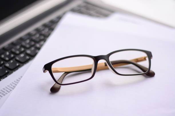 Office desk, glasses and computer working scene - business concept